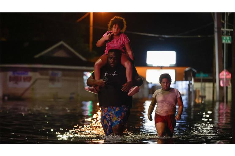 27. September, Florida, USA: Ein Mann geht mit seinen beiden Töchtern  durch die Fluten des Hurrikans „Helene“.