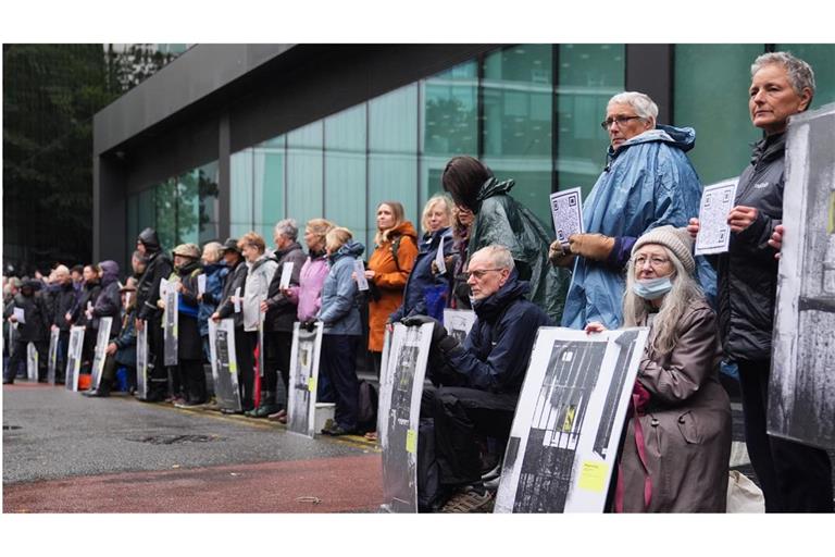 Aktivisten von Just Stop Oil halten vor dem Southwark Crown Court im Süden Londons Schilder.