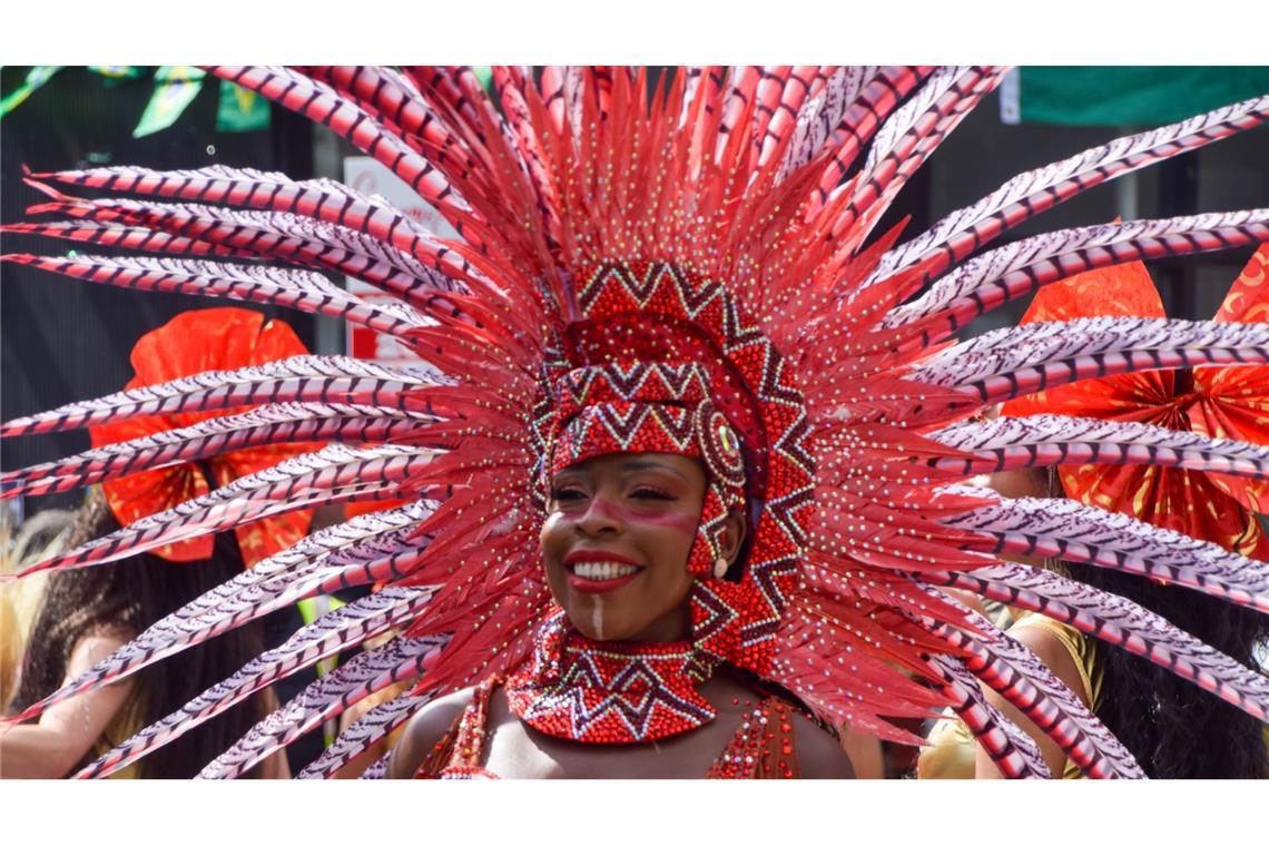 Am zweiten Tag des diesjährigen Notting Hill Carnival wirbelt eine Tänzerin in einem spektakulären Kostüm über die Straße in London.