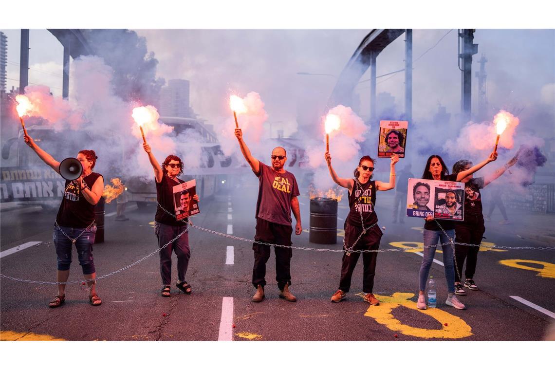 Angehörige, Freunde und Unterstützer der israelischen Geiseln, die von der Hamas in Gaza entführt wurden, nehmen mit viel Pyrotechnik an einer Protestaktion teil und blockieren eine Straße in Tel Aviv.