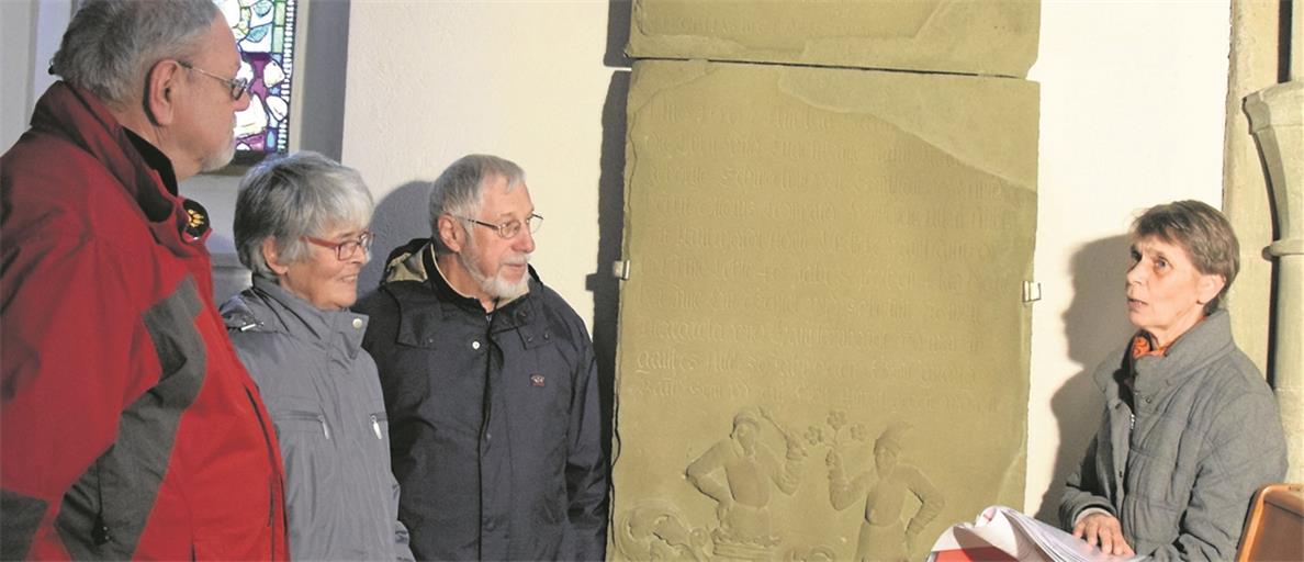 Angelika Szöke (rechts) hat sich intensiv mit den Erinnerungstafeln und den Hintergründen befasst. Unter den Exemplaren in der Walterichskirche sind auch einige, die über die Lebens- und Familiengeschichte von Frauen Auskunft geben – sie waren mit prominenten geistlichen und weltlichen Persönlichkeiten der Walterichstadt verheiratet. Martin Pfender, Gisela Jakubek und Hans-Georg Zenker (von rechts) lauschen der Kirchenführerin, die gerade die steinerne Erinnerungstafel für Otto Leonhard Hofseß und seine Frau erläutert. Foto: E. Klaper