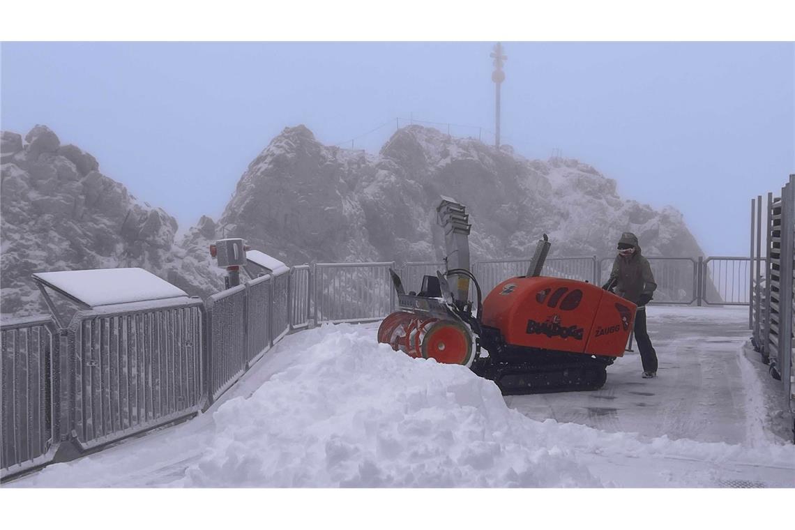 Angestellte räumen den Schnee von der Besucherplattform auf der Zugspitze.