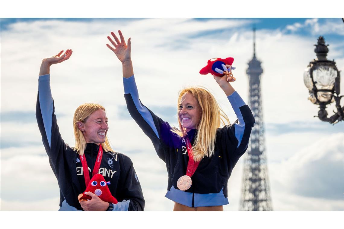 Anja Renner (r) und ihr Guide Maria Paulig bejubeln die Bronzemedaille im Triathlon vor dem Eiffelturm.