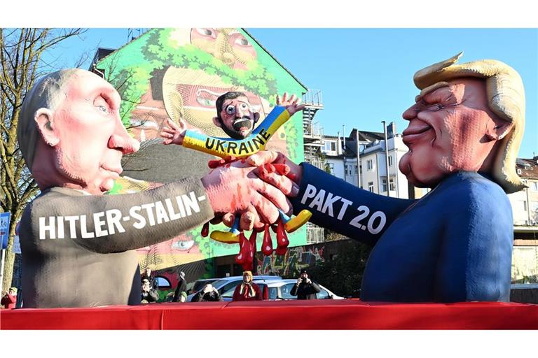 Auf einem der Düsseldorfer Rosenmontagswagen schließen Donald Trump und Wladimir Putin einen "Hitler-Stalin-Pakt 2.0" auf Kosten der Ukraine ab.