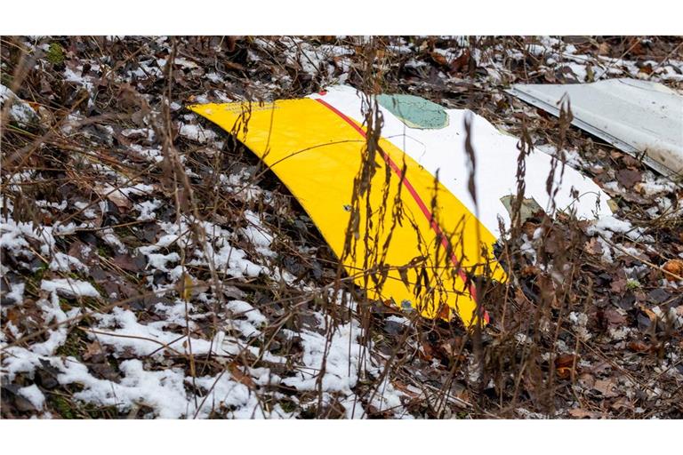 Auf einem Trümmerteil des abgestürzten Flugzeugs sind die DHL-Farben zu sehen.