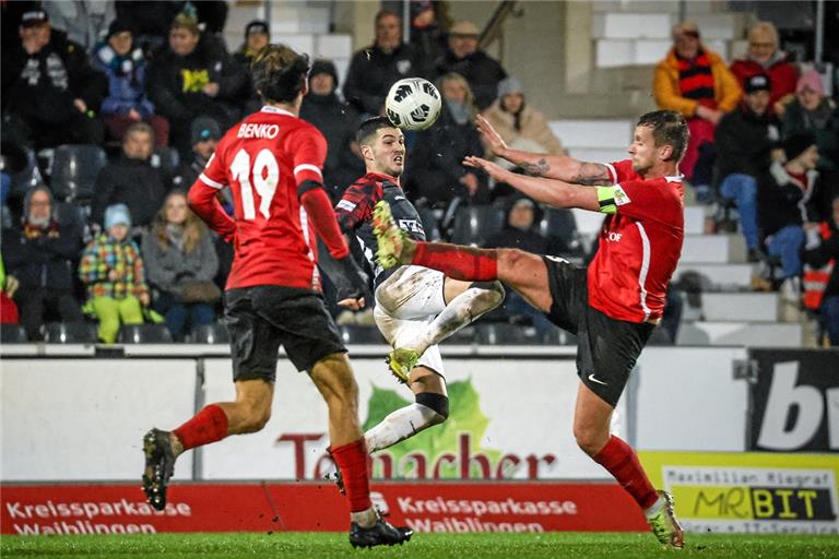 Backnang und Mert Tasdelen (Mitte) lieferten sich mit Großaspachs Team um Kapitän Manuel Konrad (rechts) und Mittelfeldmann Fabian Benko ein enges Duell. Eines, bei dem es auf dem nassen und schmierigen Rasen viel Spannung und viel Kampf gab. Foto: Alexander Becher