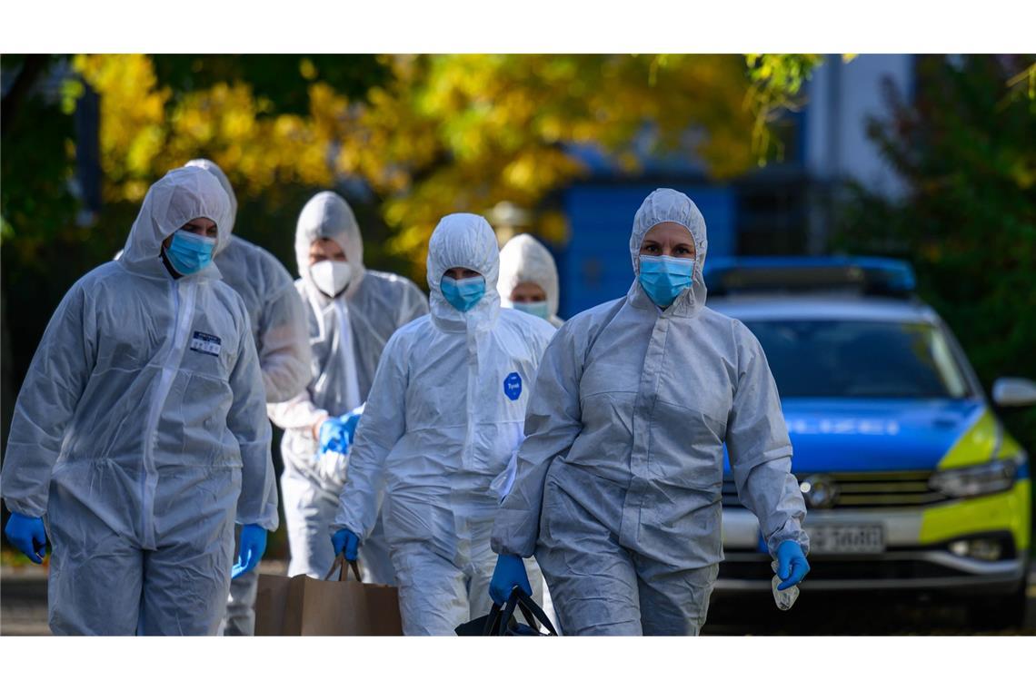 Beamte einer Tatortgruppe gehen in ein Mehrfamilienhaus in Leipzig.