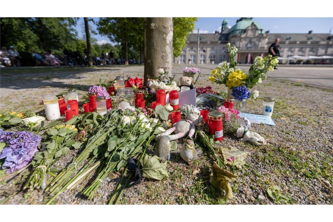 Blumen, Kerzen und handgeschriebene Trauerbekundungen stehen an einem Baum im Kurpark Bad Oeynhausen. Jetzt steht die Anklage.