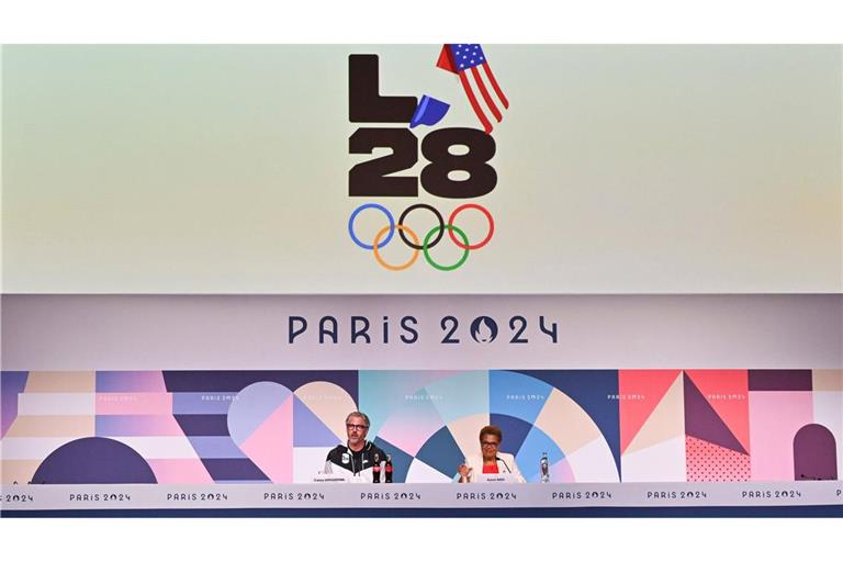 Bürgermeisterin Karen Bass (re.) und das Logo der Olympischen Sommerspiele 2028 in Los Angeles.