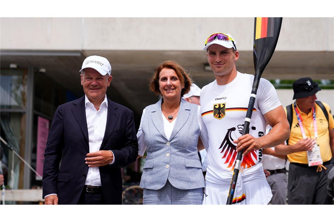 Bundeskanzler Olaf Scholz (l) und seine Frau Britta Ernst lassen sich mit Olympiasieger Tom Liebscher-Lucz fotografieren.