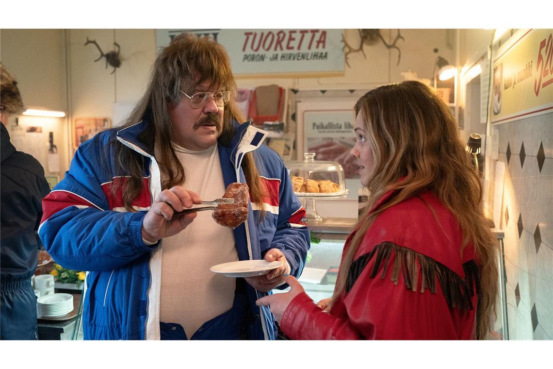 Chefredakteur Esko (Hannu-Pekka Björkman) bietet Reporterin Niina (Oona Airola) Raketen-Donuts an.