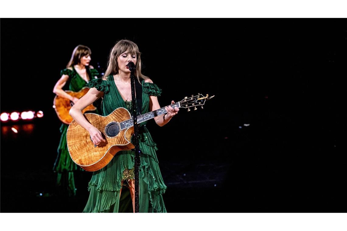 Country-Taylor: Wenn Swift zur Gitarre greift, spielt sie Lieder aus ihrer frühen Schaffenszeit – dann trägt sie Rüschenkleider in Flaschengrün  ...