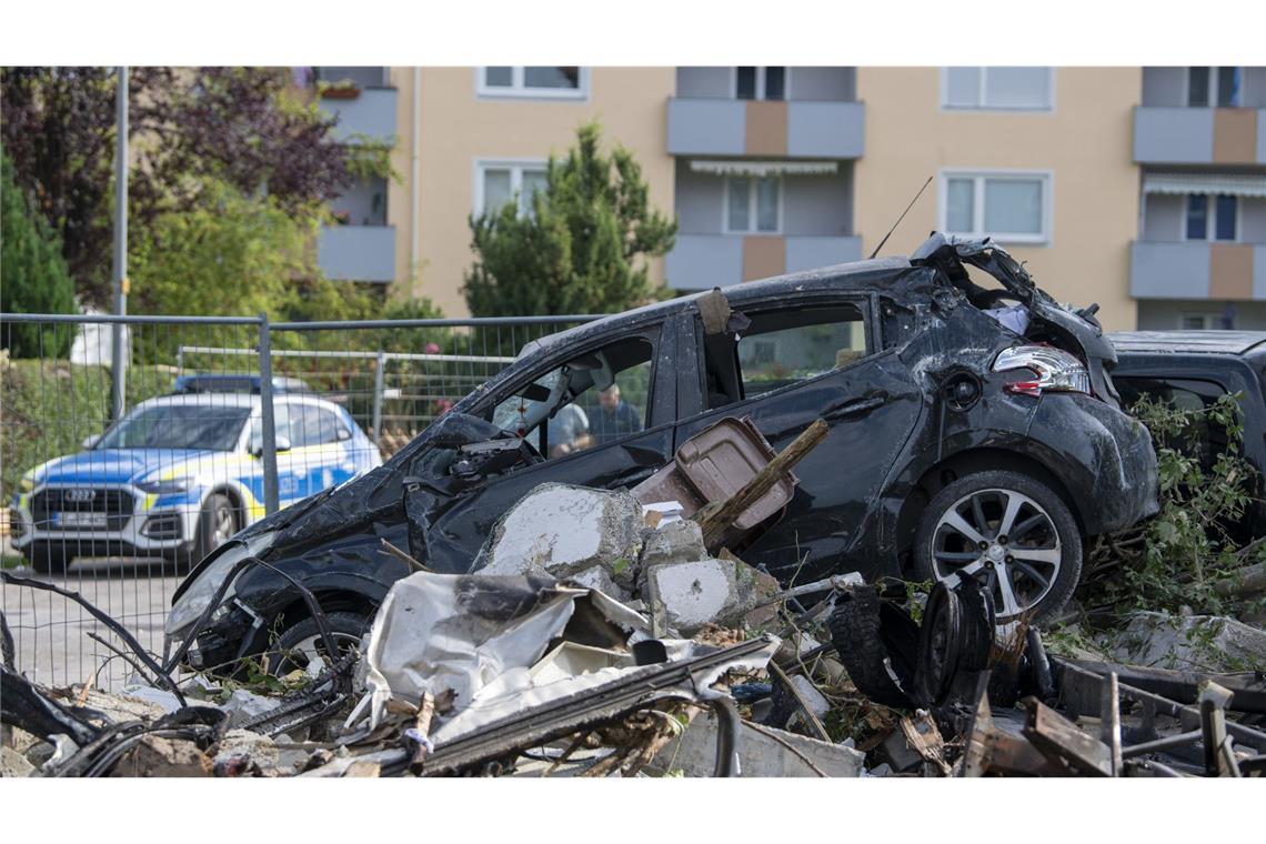 Das Wrack eines Autos liegt auf Trümmern eines Hauses.