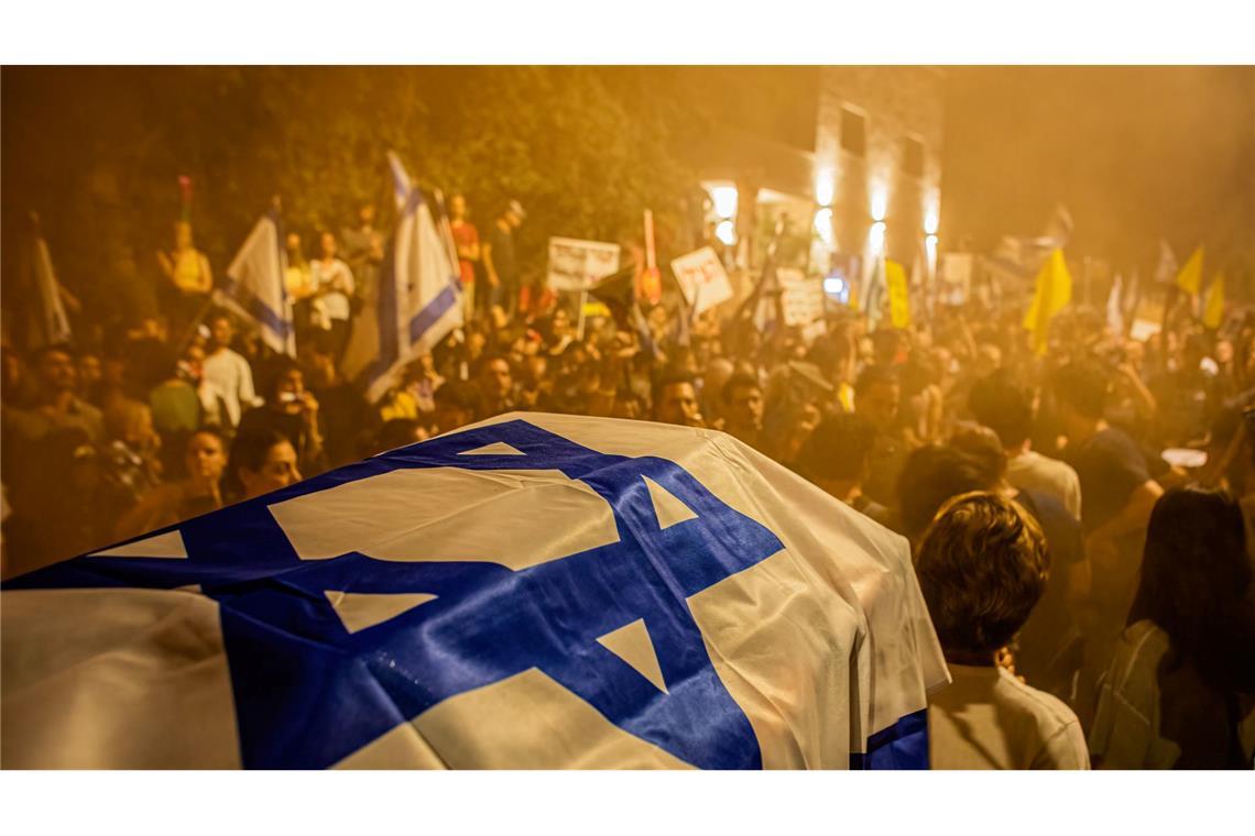 Demonstranten versammeln sich hinter einer Sargattrappe während einer Demonstration in Tel Aviv.