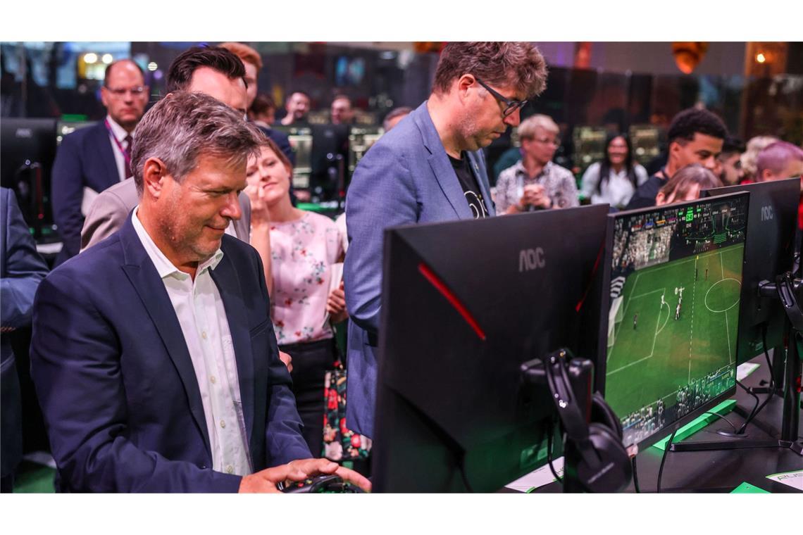 Der Bundeswirtschaftsminister Robert Habeck und sein Staatssekretär Michael Kellner (beide Grüne) spielen bei der Gamescom ein Fußballspiel zur Probe.