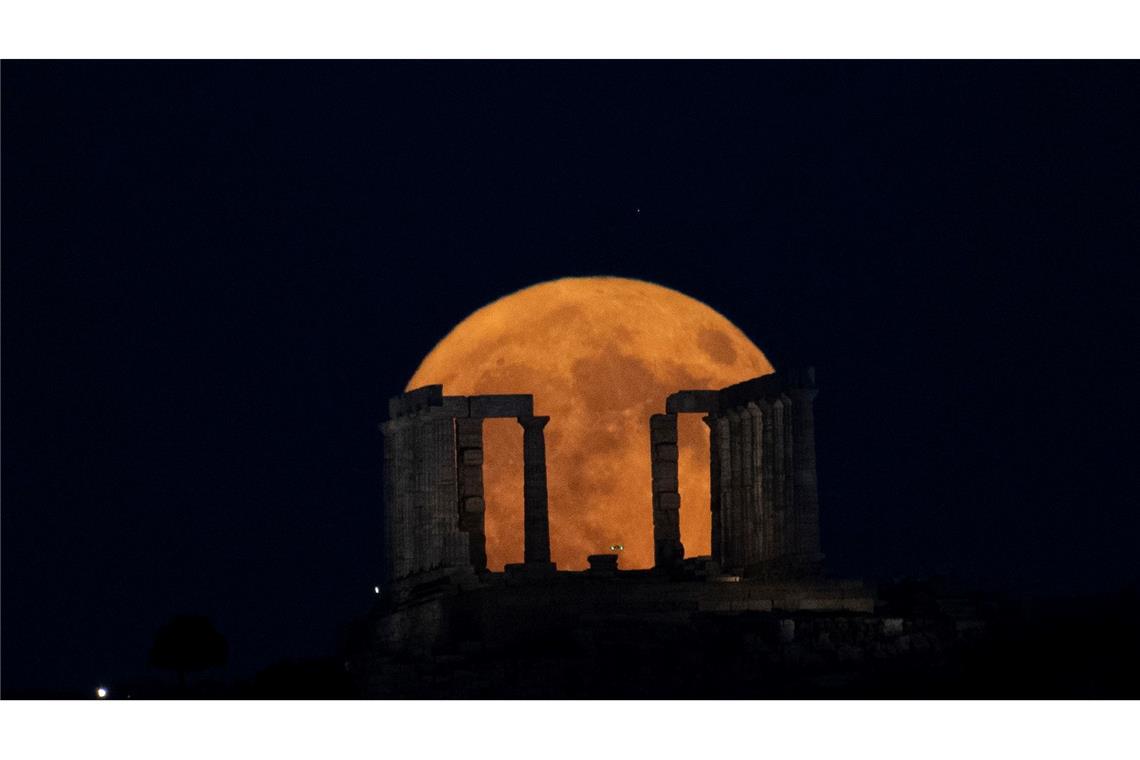 Der Supermond geht hinter dem Poseidon-Tempel am Kap Sounio südlich von Athen auf.