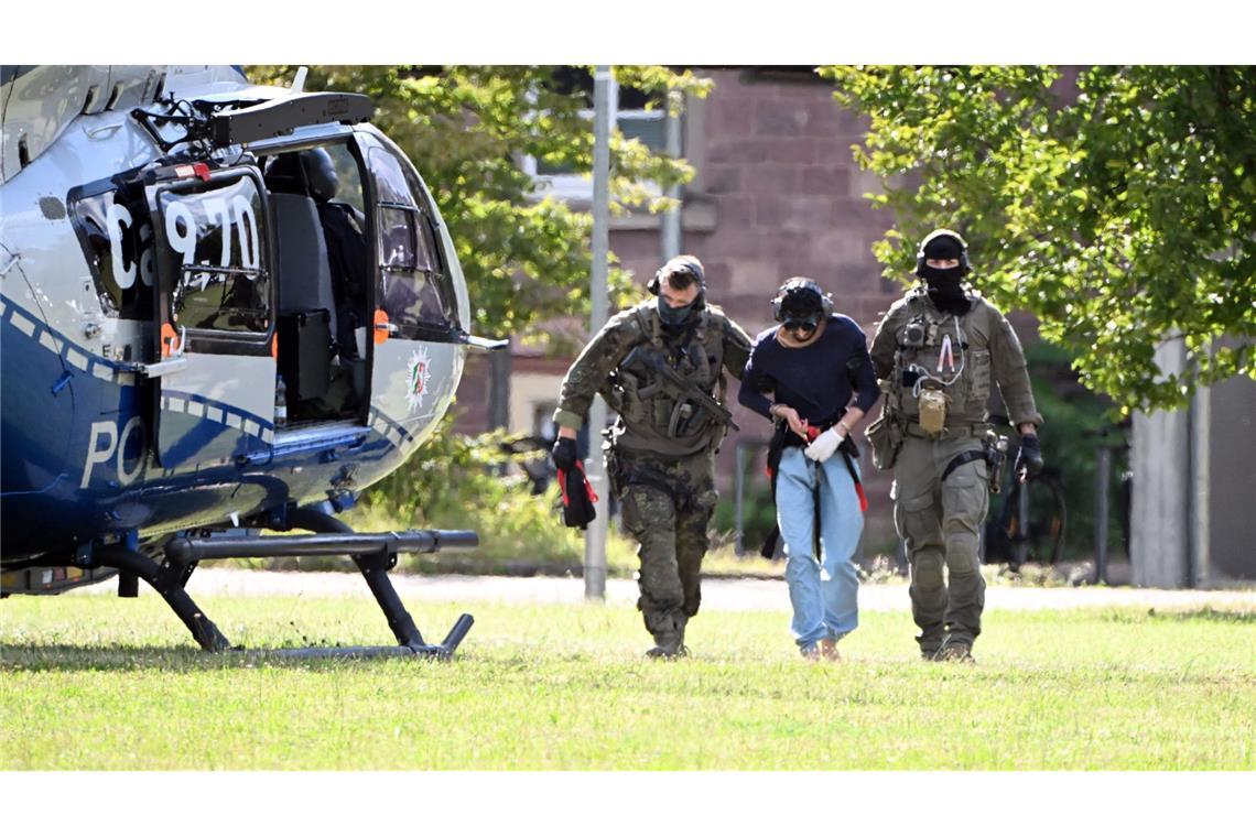 Der Tatverdächtliche wurde in Karlsruhe von bewaffneten Polizisten in Spezialausrüstung vom Helikopter zu einer Wagenkolonne gebracht.