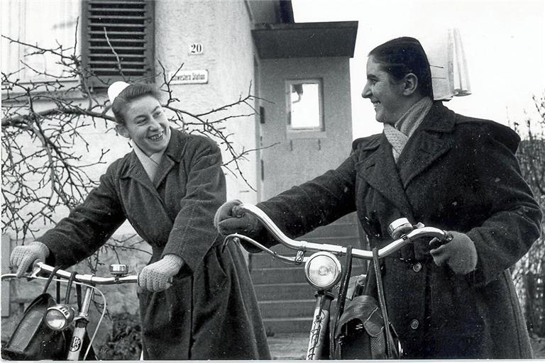 Die beiden Gemeindeschwestern Hanne Fetzer und Meta Wörner (von links), die mit Fahrrädern unterwegs waren, 1964 vor dem Aufgang zur Schwesternstation. Das modernisierte Gebäude ist heute der Sitz von Diakonie ambulant. Fotos: Diakoneo/Diak-Archiv Schwäbisch Hall