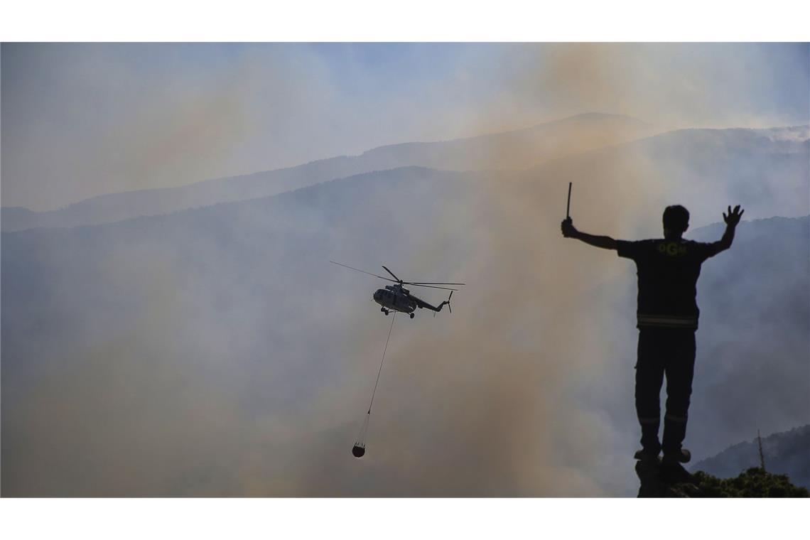 Die Feuerwehr bekämpft den Brand mit Unterstützung von Hubschraubern.