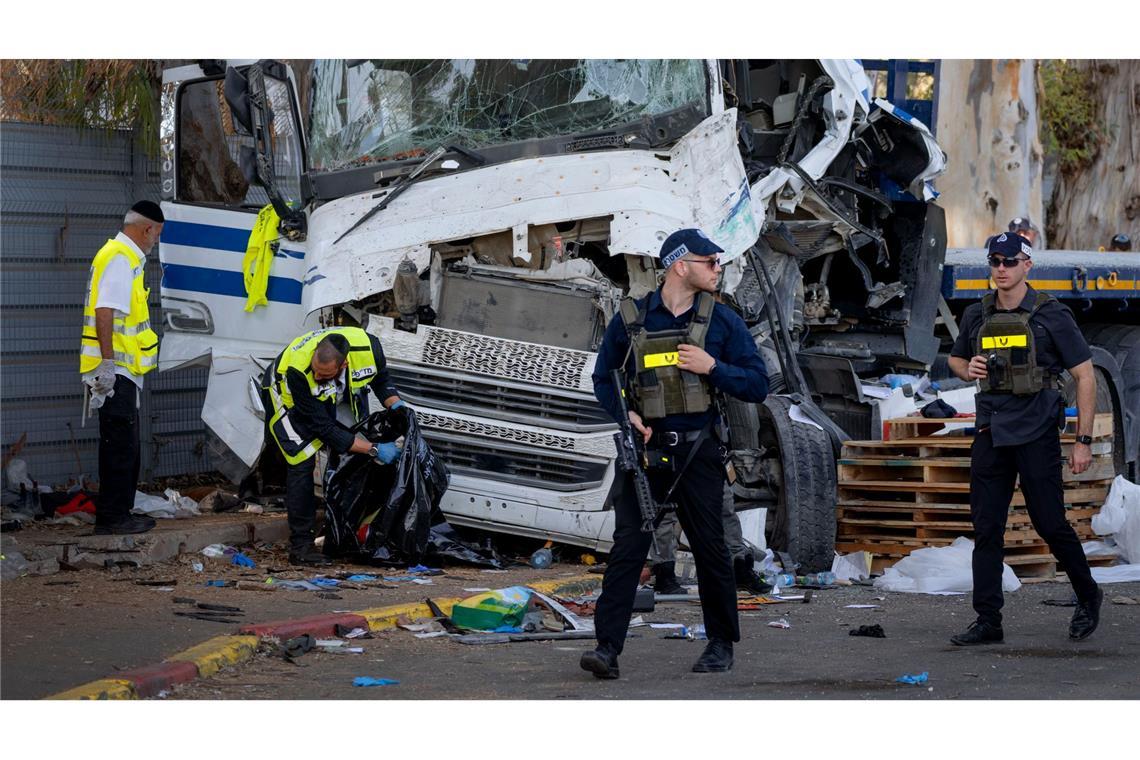 Die israelische Polizei und die Rettungsdienste inspizieren den Ort, an dem ein Lastwagenfahrer eine Bushaltestelle in der Nähe eines Armeestützpunktes gerammt und dabei Dutzende von Menschen verletzt hat.