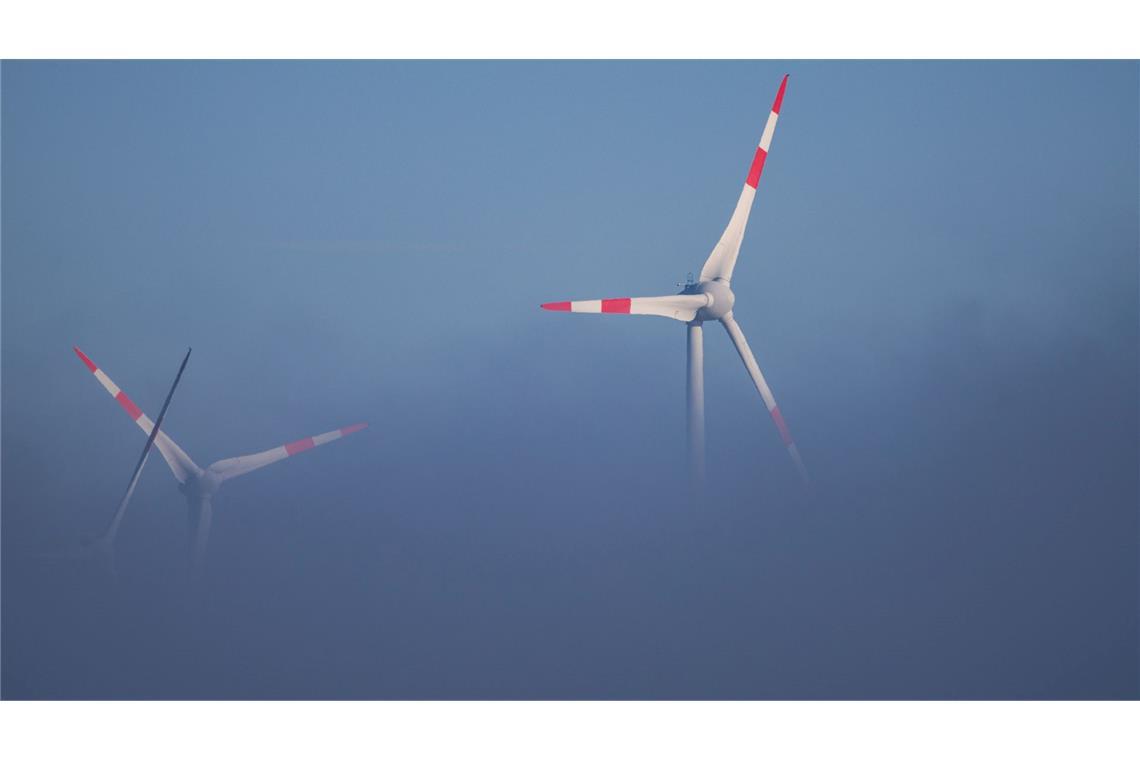 Die Rotoren von Windkraftanlagen ragen aus dem Bodennebel in Norddeutschland.