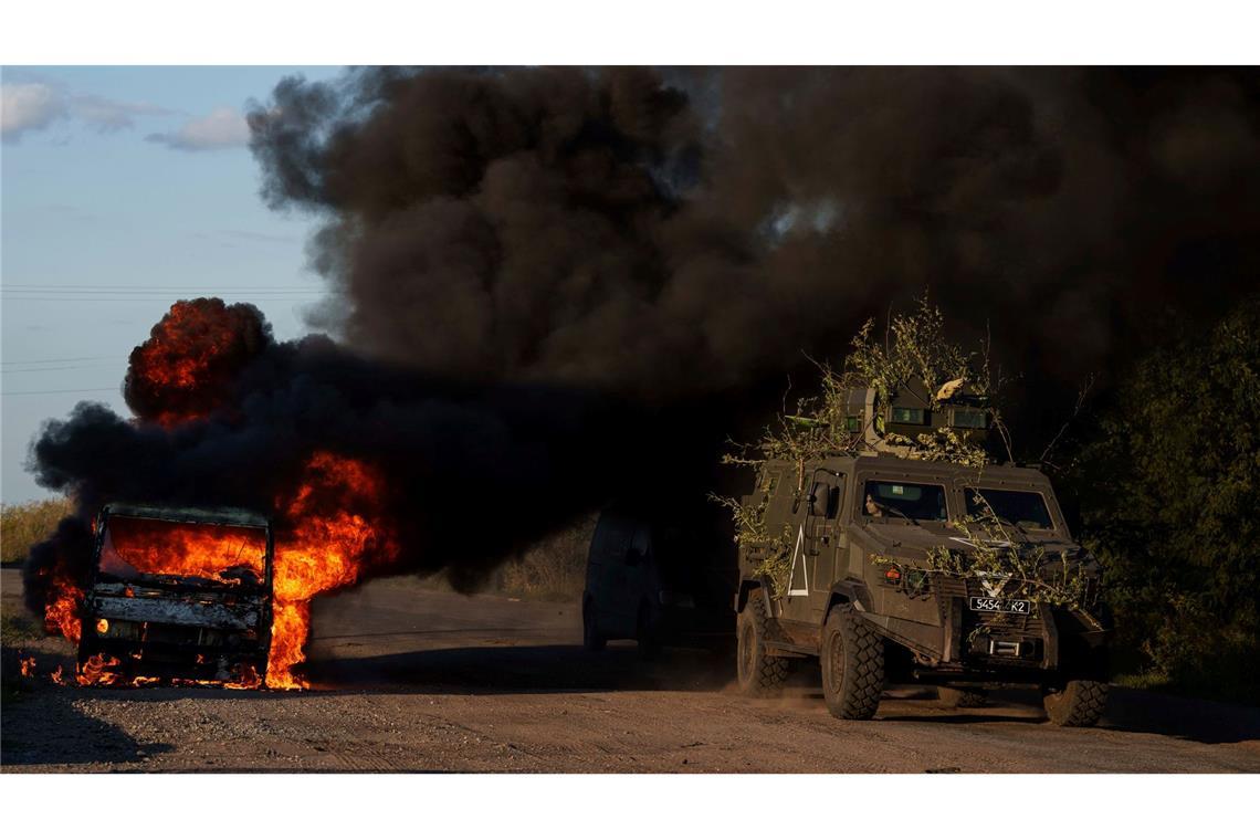 Die Ukraine trägt den Krieg jetzt nach Russland: Ein gepanzertes ukrainisches Militärfahrzeug fährt an einem brennenden Auto nahe der russisch-ukrainischen Grenze in der Region Sumy in der Ukraine vorbei.