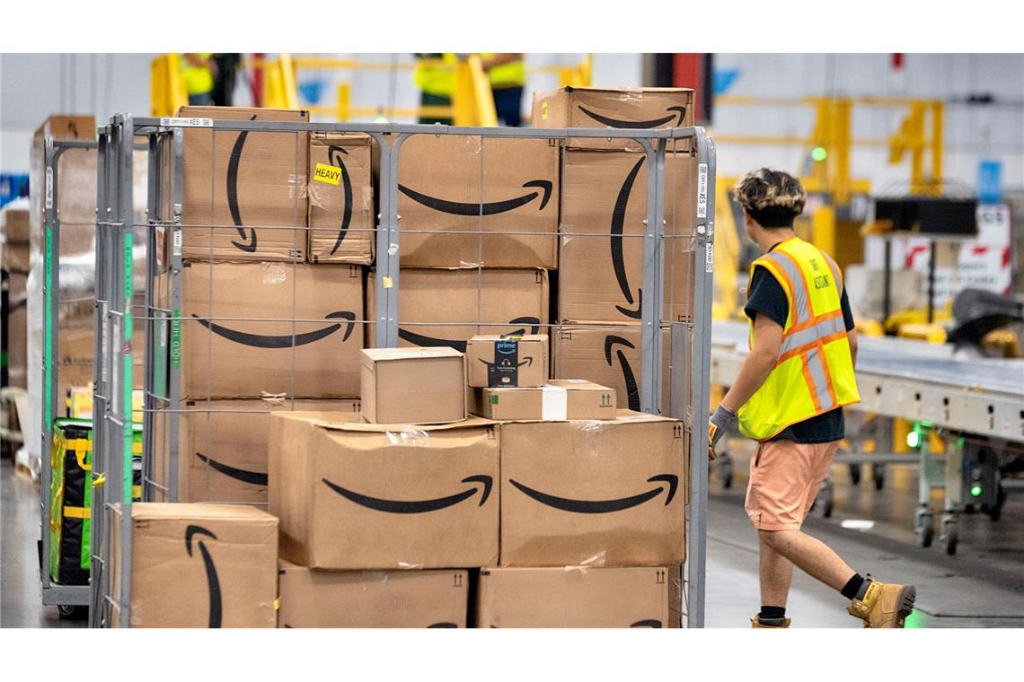 Ein Amazon-Mitarbeiter geht an Paketen vorbei, die auf einem Wagen auf dem Boden der DAX7-Lieferstation während des jährlichen Prime Day-Events von Amazon liegen.