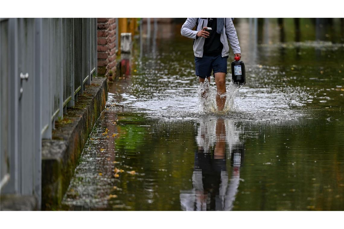 Ein Anwohner einer überfluteten Straße in Frankfurt Oder watet durch das Wasser.