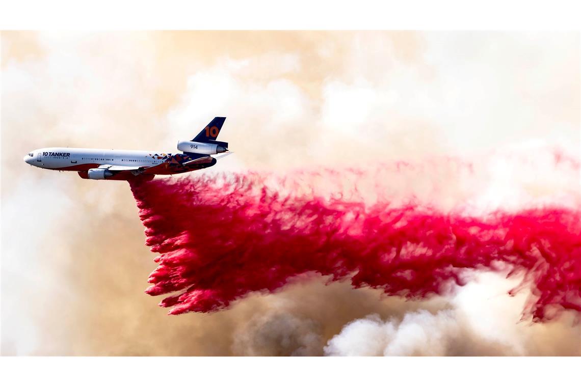 Ein Flugzeug wirft Löschmittel über dem Mandeville Canyon in Los Angeles ab.