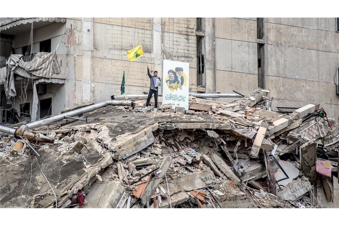 Ein Hisbollah-Anhänger schwenkt eine Flagge in Dahieh im Großraum Beirut nach Beginn der Waffenruhe.