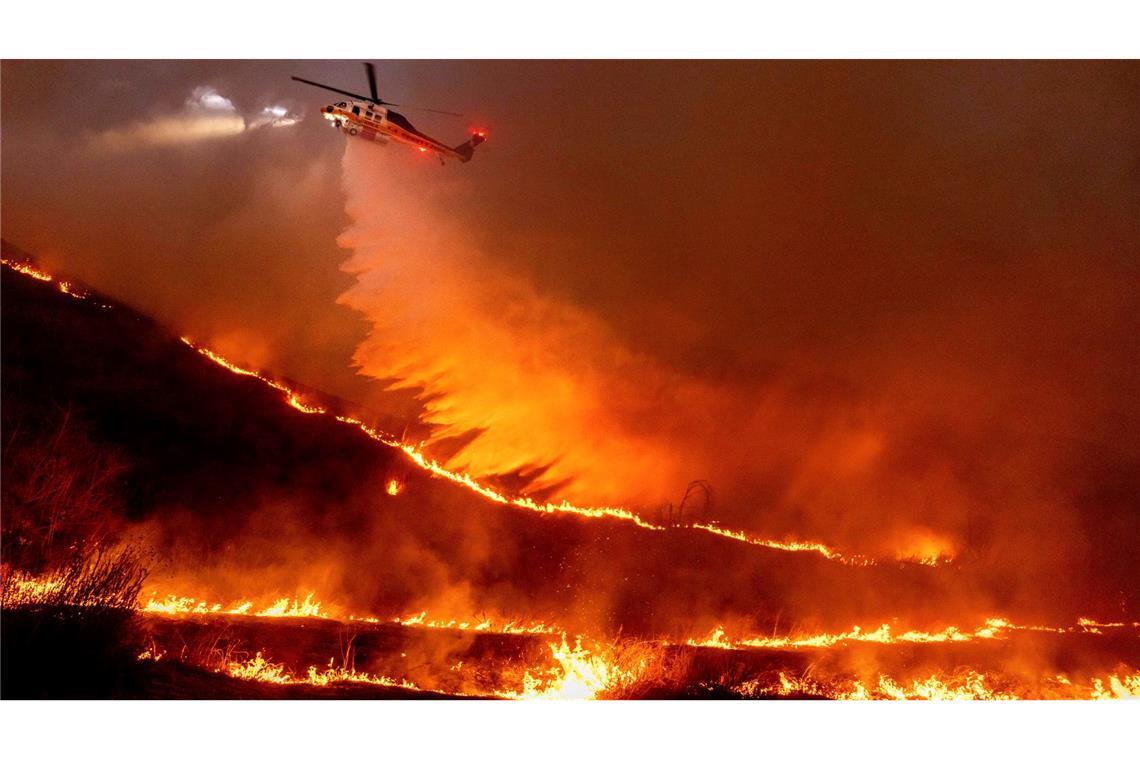 Ein Hubschrauber wirft Wasser über dem "Kenneth Fire" ab.