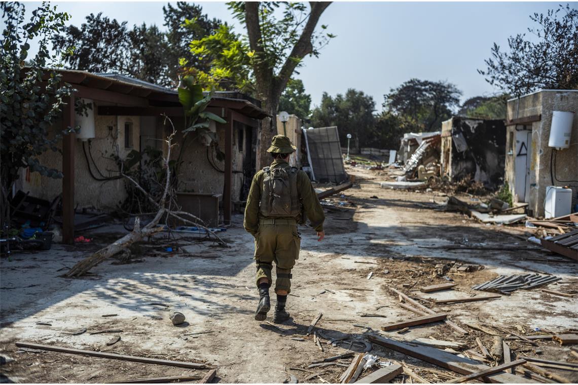 Ein israelischer Soldat geht an zerstörten Häusern im Kibbuz Kfar Aza vorbei. Der Kibbuz war im Oktober 2023 von Hamas-Terroristen angegriffen worden. Viele Bewohner wurden ermordet.