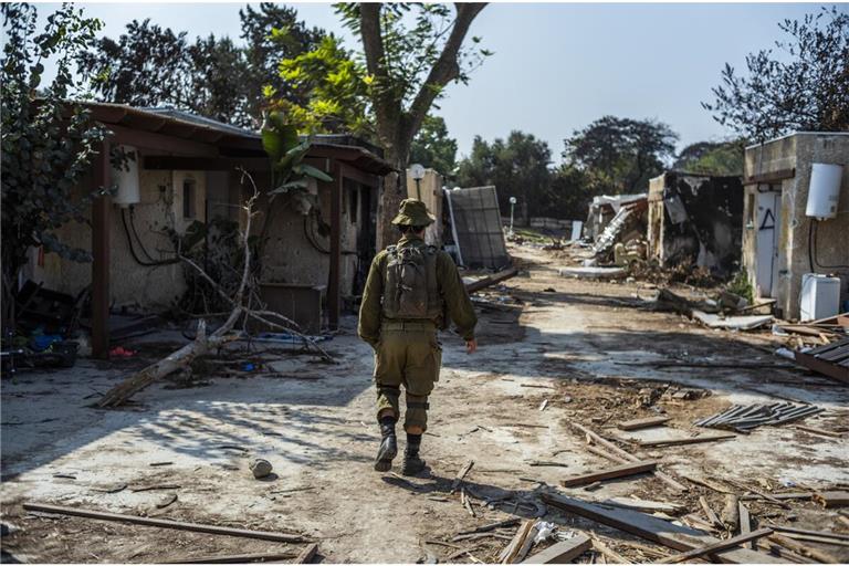 Ein israelischer Soldat geht an zerstörten Häusern im Kibbuz Kfar Aza vorbei. Der Kibbuz war im Oktober 2023 von Hamas-Terroristen angegriffen worden. Viele Bewohner wurden ermordet.