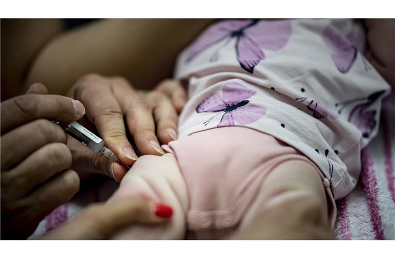 Ein Kinderarzt verabreicht einem Kleinkind eine Kombinationsimpfung-Impfung zur Grundimmunisierung. Die Sechsfach-Impfung schützt gegen Diphtherie, Tetanus, Pertussis, Poliomyelitis, Haemophilus influenzae Typ b und Hepatitis B.