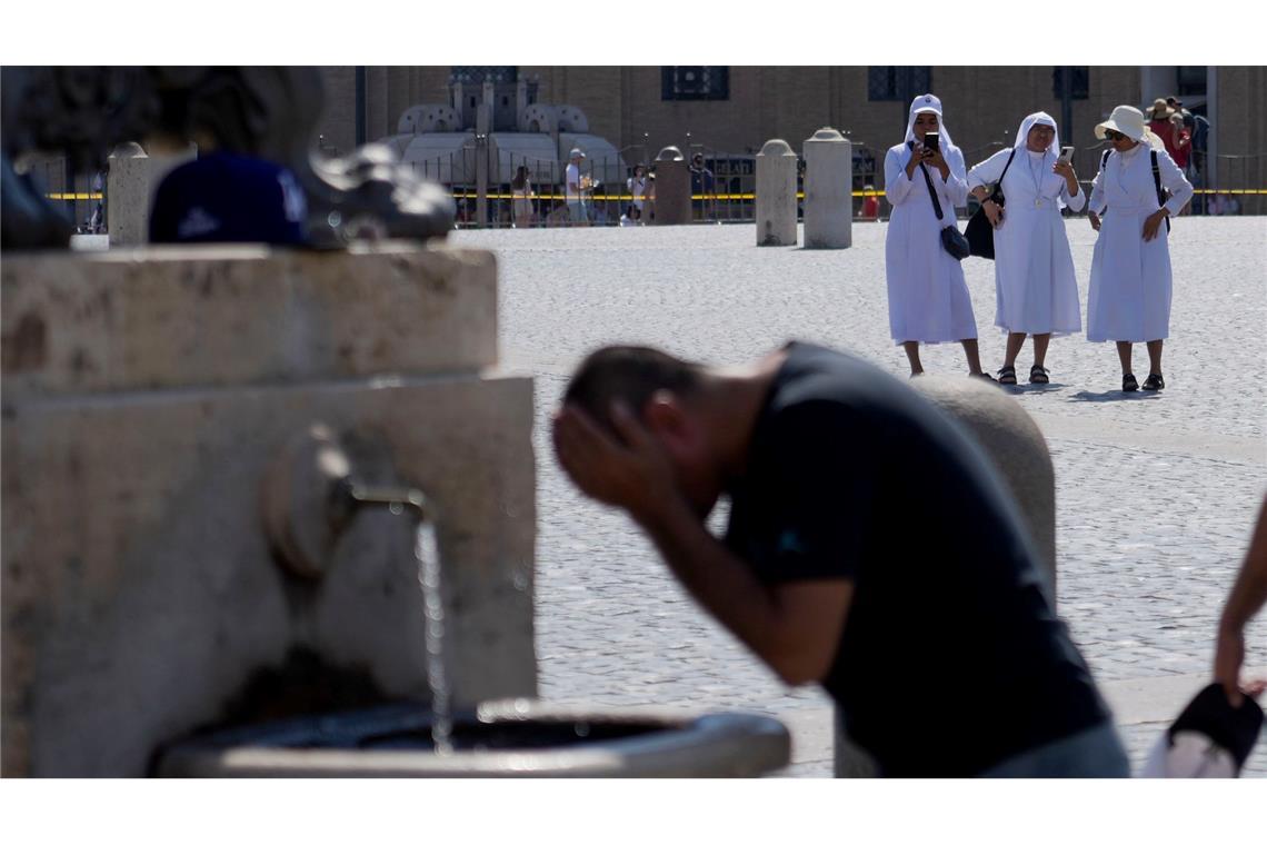 Ein Mann erfrischt sich an einem Brunnen auf dem Petersplatz, während die Temperaturen bis zu 38 Grad Celsius im Vatikan erreichen.