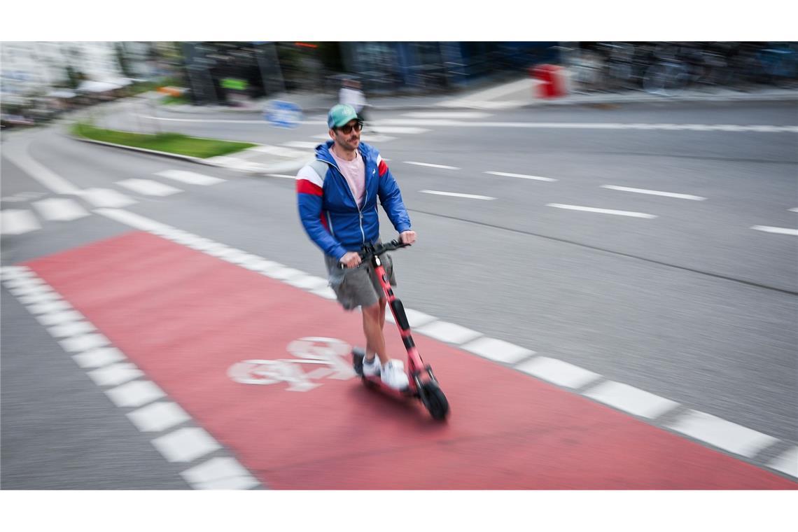 Ein Mann fährt auf einem Radweg in Hamburg mit einem E-Scooter.