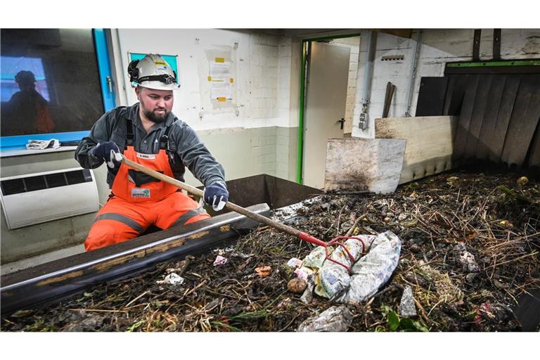 Ein Mitarbeiter eines Abfallentsorgungszentrums sortiert Plastikteile aus dem Biomüll heraus. (Symbolbild)