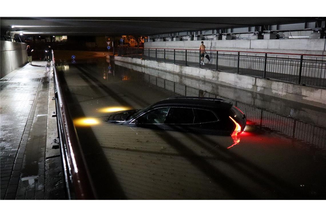 Ein Pkw steht nach einem schweren Gewitter in Bruchsalbis zur Motorhaube im Wasser.