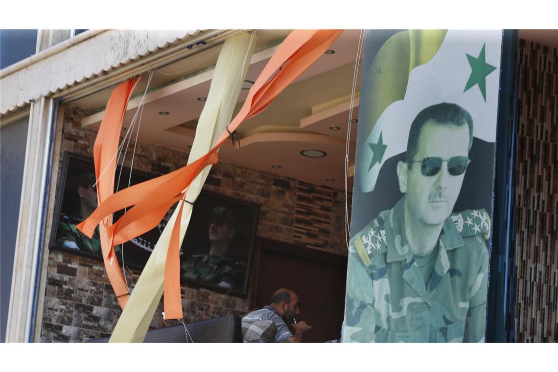 Ein Plakat zeigt den syrischen Präsidenten Assad vor einem zerbrochenen Fenster in der Provinz Hama in Zentralsyrien.