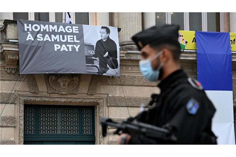 Ein Polizist steht neben der Opera Comedie, an deren Fassade eine Hommage an den enthaupteten Lehrer Samuel Paty angebracht ist (Archivfoto).