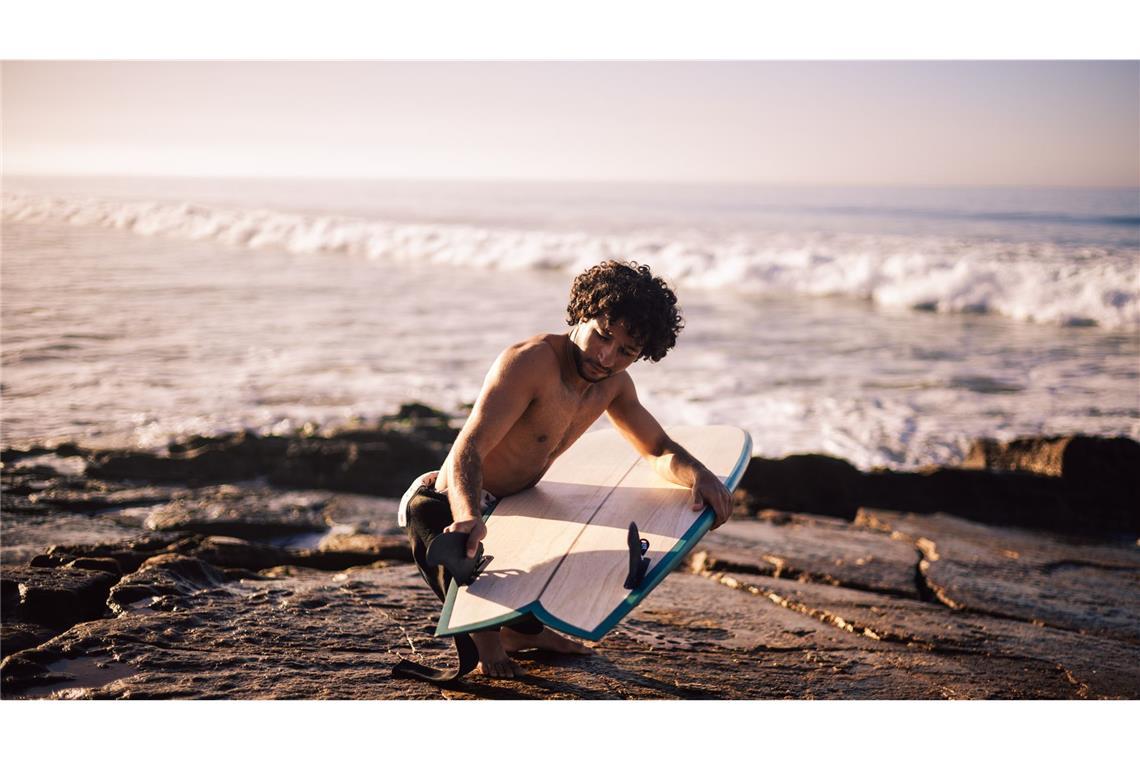 Ein Surfer in Marokko begutachtet das nachhaltige Board.