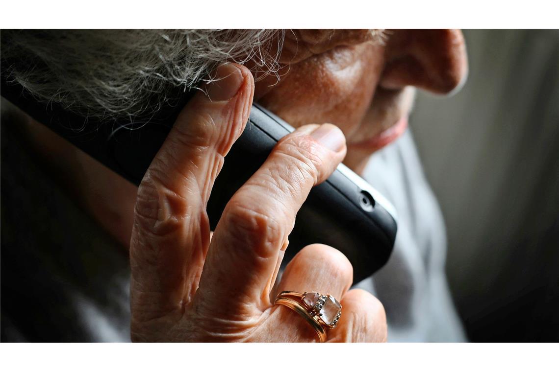 Eine ältere Frau telefoniert mit einem schnurlosen Festnetztelefon. In Weingarten ist eine Frau Opfer von Schockanrufern geworden (Symbolfoto).