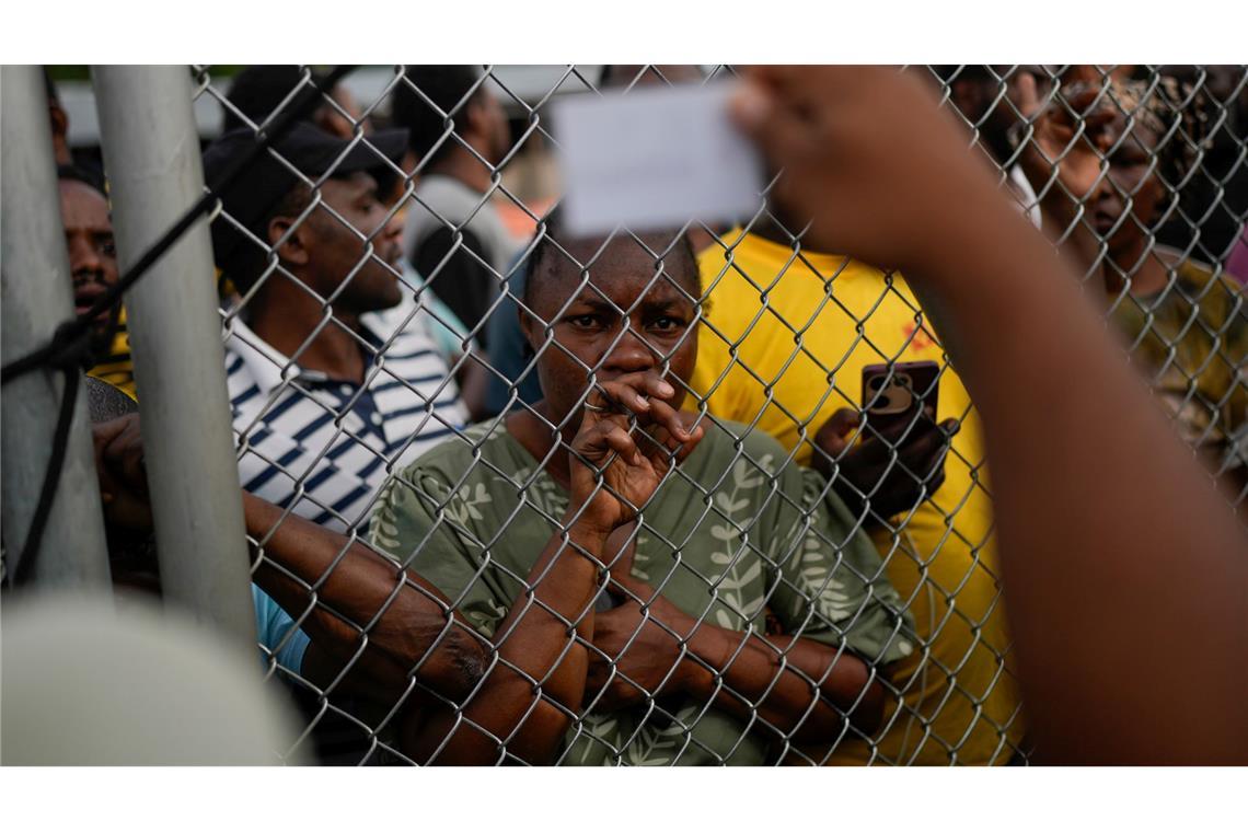 Eine angolanische Migrantin schaut auf einen panamaischen Offizier in Lajas Blancas, nachdem sie den Darien Gap von Kolumbien aus überquert hat, in der Hoffnung, die USA zu erreichen.