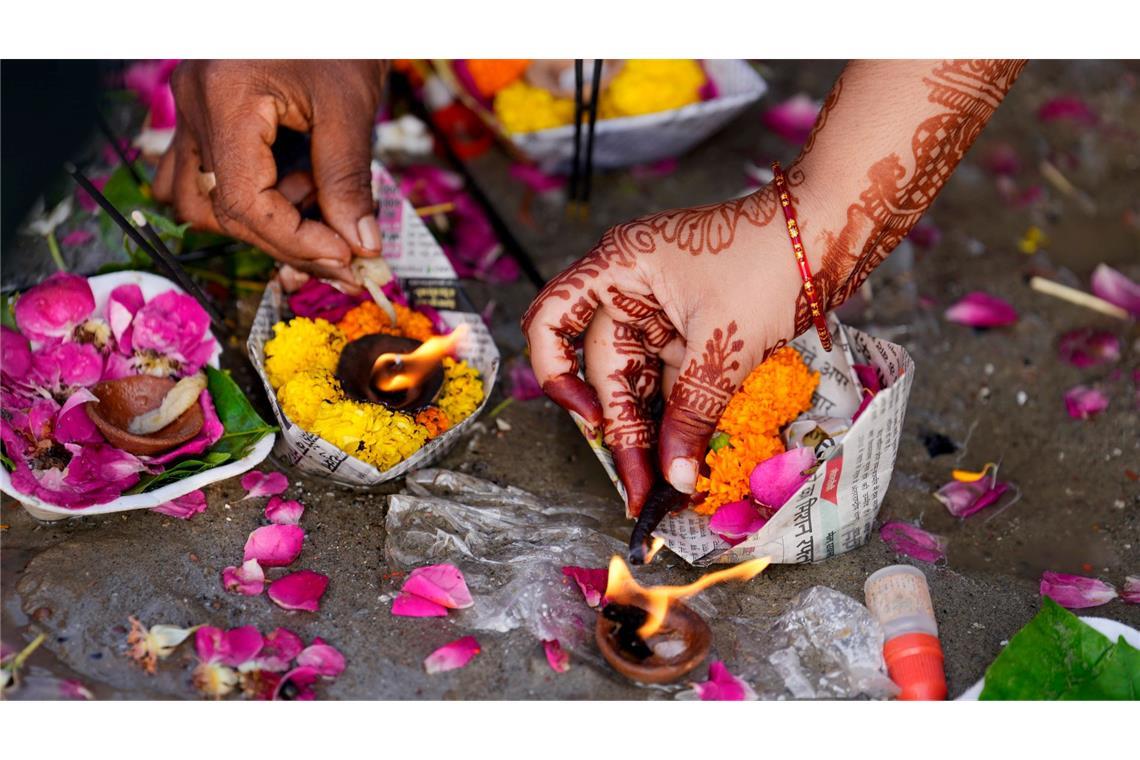 Eine Frau betet beim Teej-Fest und führt ein hinduistisches Opferritual in Prayagraj durch. In dem Ort fließen die Flüsse Ganges und Yamuna zusammen, weshalb er für Hindus eine besondere Bedeutung hat.