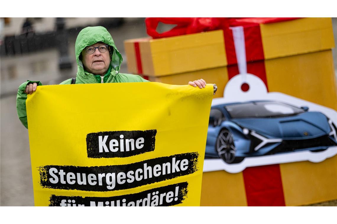 Eine Greenpeace-Aktivistin auf einem Protest für eine Milliardärssteuer am Brandenburger Tor.