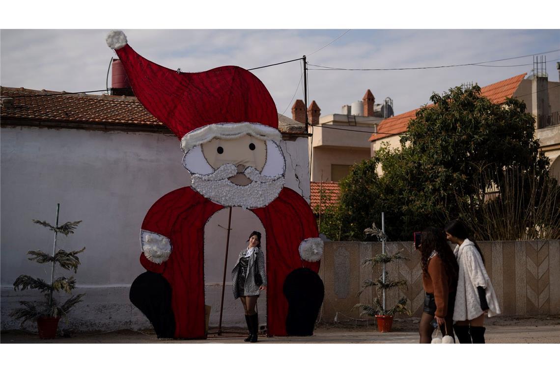 Eine junge Frau posiert für ein Foto an einer Weihnachtsdekoration auf einem Platz in einem christlichen Viertel in der syrischen Stadt Homs.