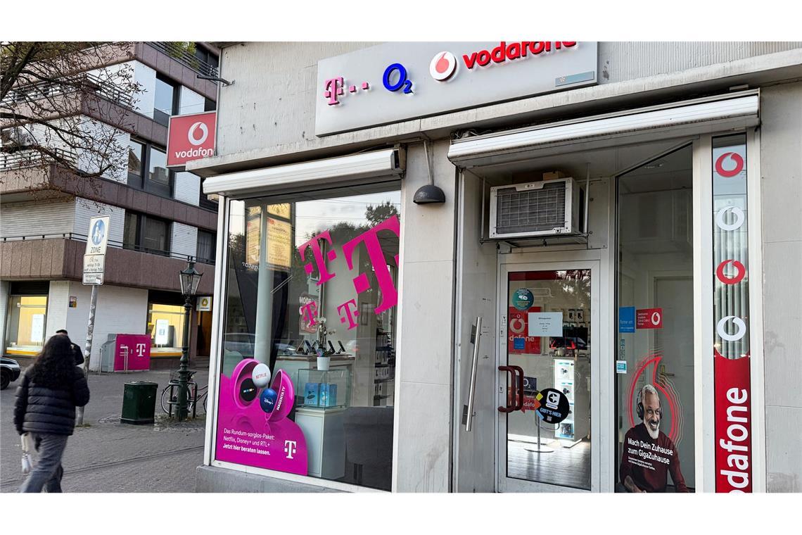 Eine Passantin geht in einer Fußgängerzone an einem Shop vorbei, der Mobilfunkverträge der drei etablierten deutschen Netzbetreiber Telekom, Telefónica O2 und Vodafone anbietet. Im Wettkampf um die Kundengunst bieten nun alle drei Anbieter Privatkunden reines 5G an, auch 5G SA genannt.