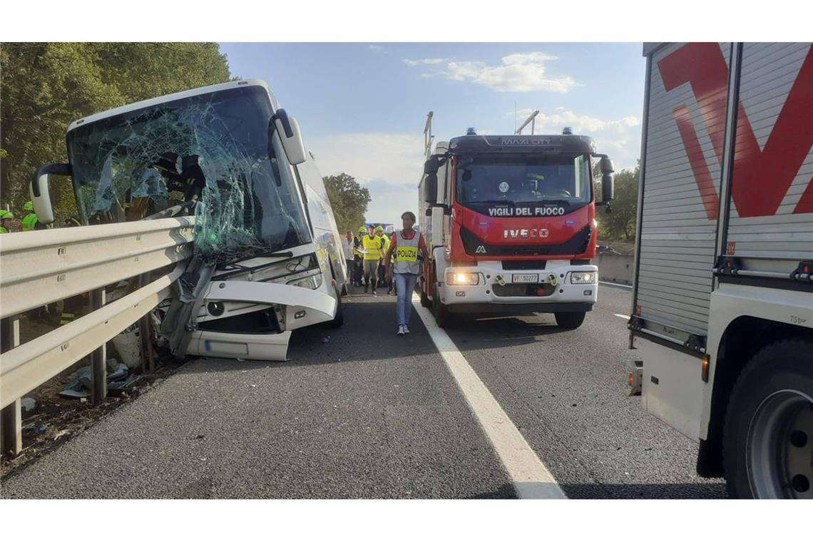 Einsatzkräfte der Feuerwehr untersuchen einen verunglückten Reisebus. In der Toskana ist es zu einen schweren Unfall gekommen.