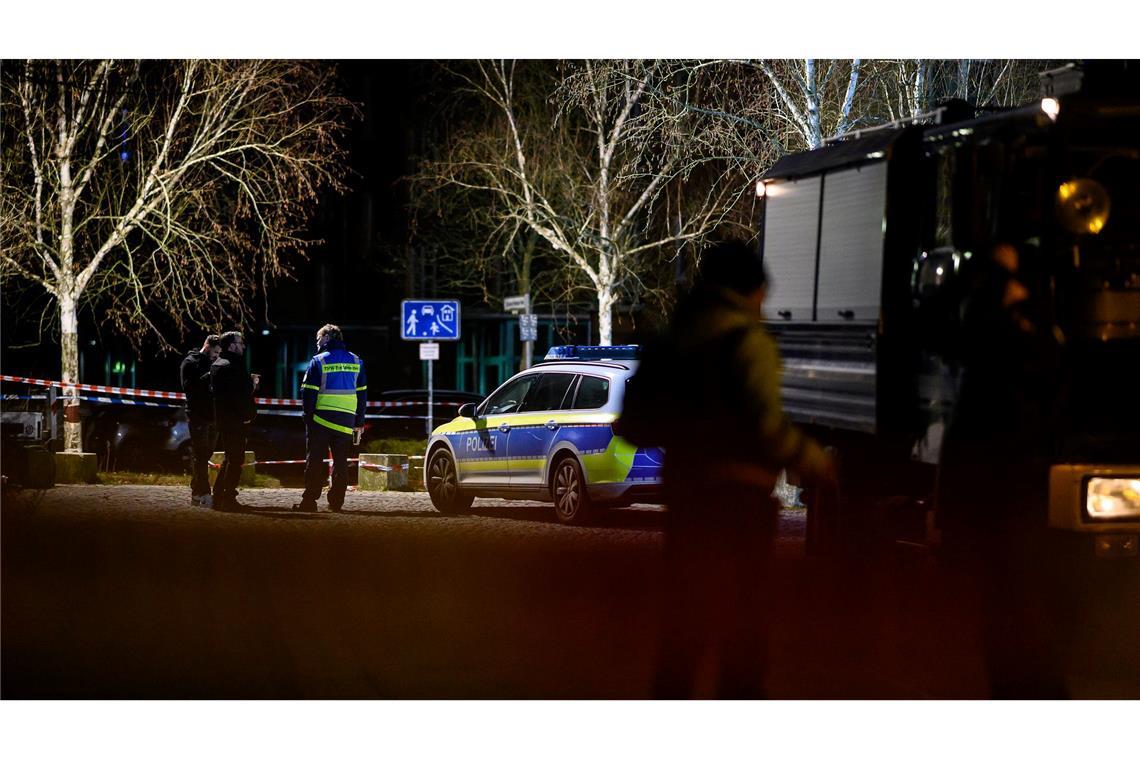 Einsatzkräfte der Polizei stehen am abgesperrten Tatort.