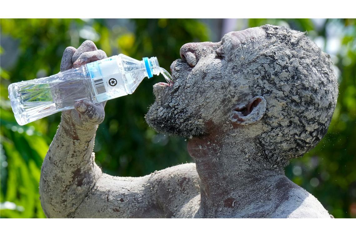 Erfrischung bei Hitze: Ein Asaro-Schlammmann trinkt einen Schluck Wasser.